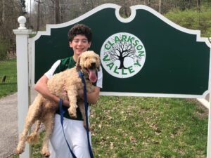 How To Prevent An Injury While Walking Your Dog | Cantor Injury Law Boy holding a dog. How To Prevent An Injury While Walking Your Dog.
