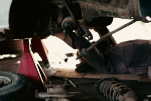 A man inspecting the internal parts of a car
